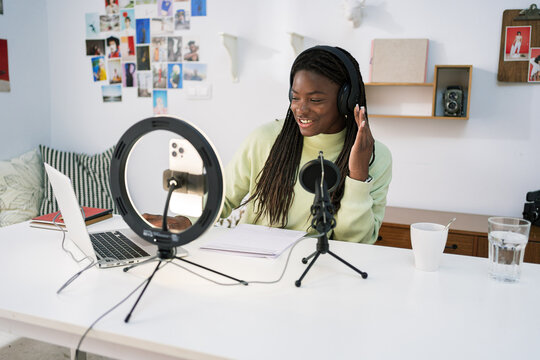 Woman recording podcast at home office