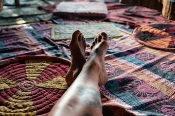 A pair of feet resting in a Jungle Treehouse with colourful carpets 