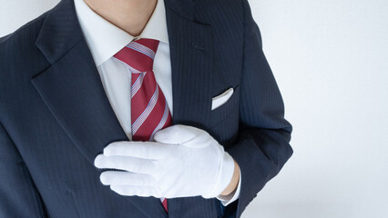 白手袋をはめたスーツ姿の男性│買取り査定イメージ