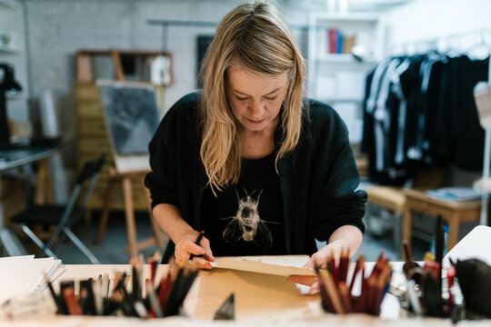 Female artist examining sketch in workshop