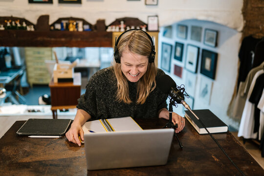 Happy woman recording podcast during video call