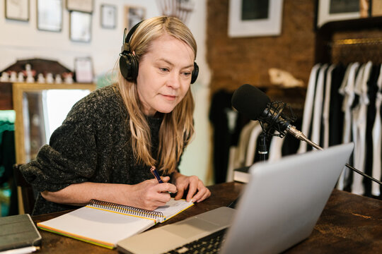 Woman taking notes and preparing for recording podcast