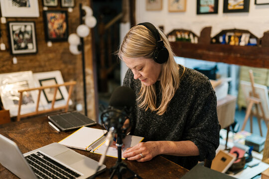 Radio host taking notes in notepad during live stream