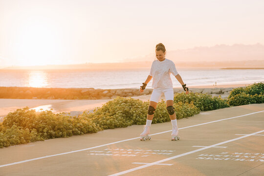 Female roller skate begginer by the sea