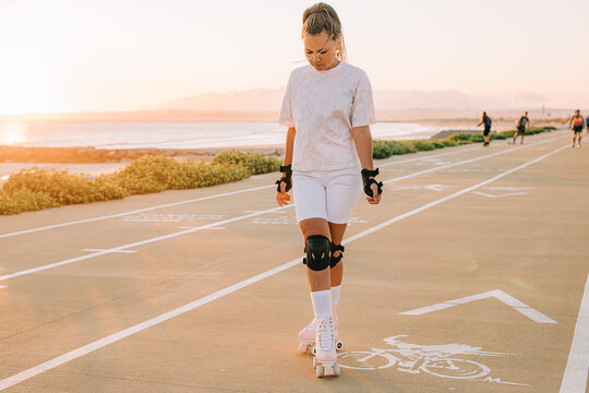 Young woman roller skating in sunset