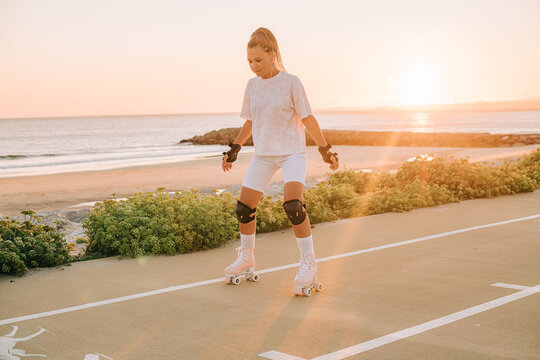 Young woman roller skating in sunset