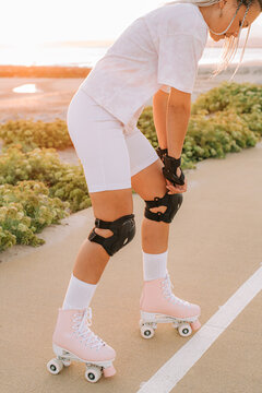 Female roller skater ajusting protection