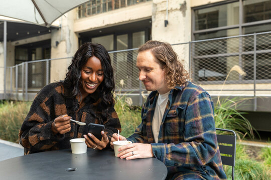 Couple Eat and Look at Phone Outside