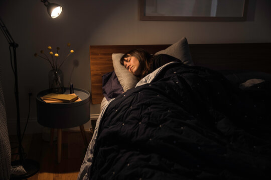 Tired sleepy woman sleeping in her bed