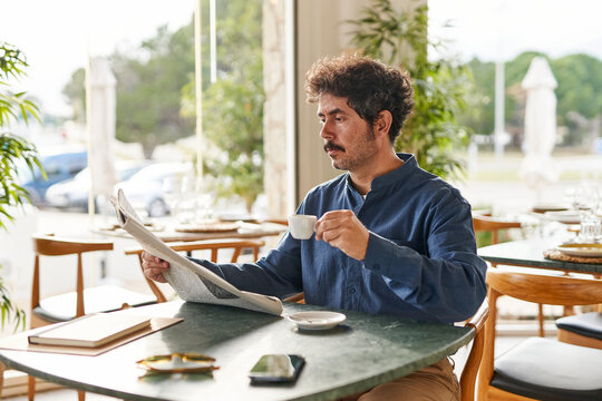 Businessman reading newspaper in cafe