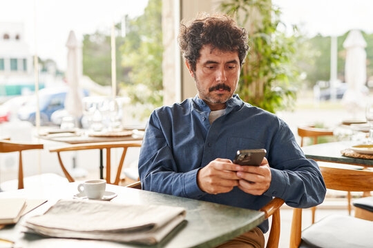 Male entrepreneur using smartphone in cafe