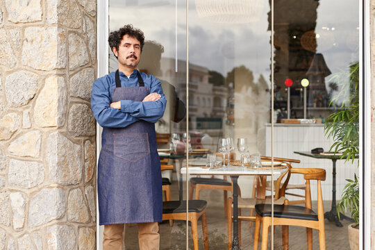 Male waiter outside restaurant in daytime