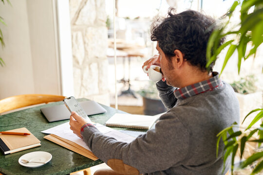 Businessman drinking coffee during work in cafe