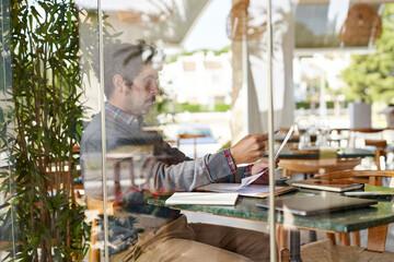 Focused businessman working with documents in cafe
