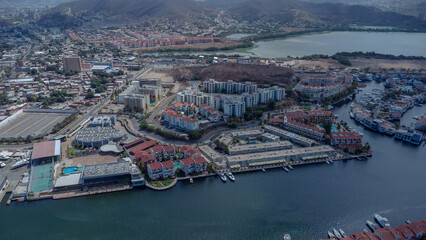 Obraz premium aerial drone shots of the beach city of Lechería, with a residential area of Venice-style stilt houses, you can see houses, editions, canals, houses on the sea, stilt houses, parking lots, swimming po