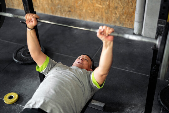 Strong sportsman doing bench press exercise