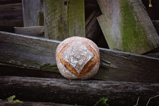 bread boule posed on a wooden beam