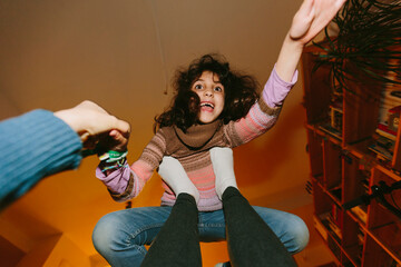 POV of Kid playing superman on her mothers feet laughing