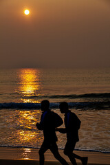 Fototapeta premium Silhouette of persons on the beach early morning