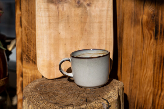 Detail of Handmade wooden cutting board and ceramic coffee mug - Powered by Adobe