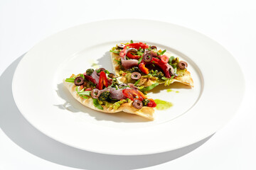 Tapas with avocado cream, anchovy, paprika and kalamata olives on focaccia. Bruschetta with guacamole and anchovy isolated on white background. Appetizer contemporary concept. Fish antipasti.
