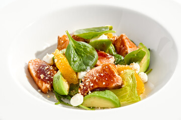 Healthy lunch - green salad with tuna, avocado and orange. Tuna salad for diet. Clean eating in restaurant menu. Grilled Fish with spinach, avocado, citrus isolated on white background. Keto diet.