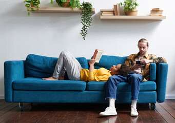 Young couple relaxing and reading in living room
