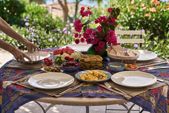 Table with different food on sunny nature background