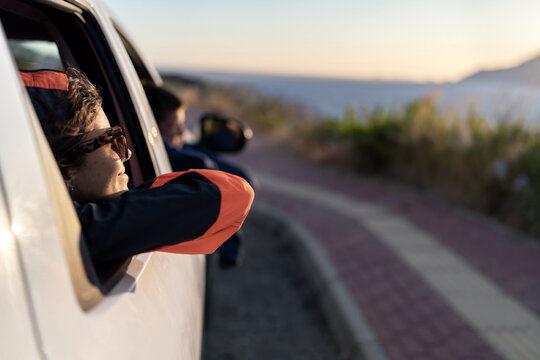 Smiling woman and boy admiring nature from auto