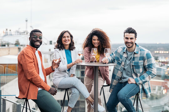 Cheerful multiethnic friends standing on rooftop