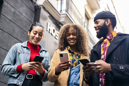 Friends using smartphone in the street