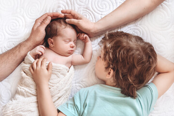 Family touching and petting the new baby.