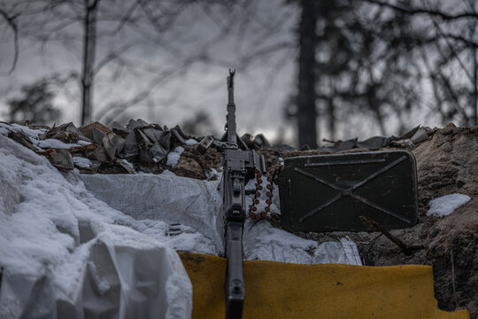 Close up of army trench with weapon among dark trees
