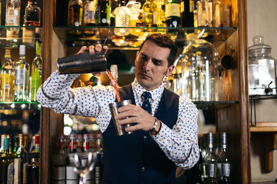 Professional bartender preparing cocktail in pub