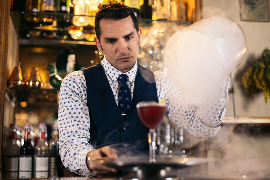 Stylish barman preparing cocktails
