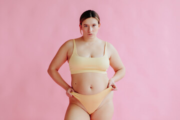 Confident plus size woman portrait pink background - Body positive