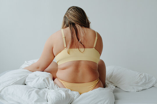 Plus size woman sit on bed - Body positive