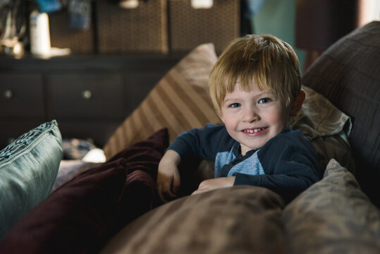 Little boy in between pillows