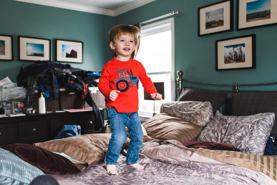 Little Boy Jumping On Bed