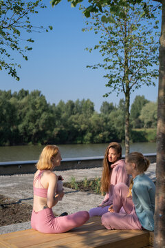 Group of young woman relaxing after outdoor training in park

