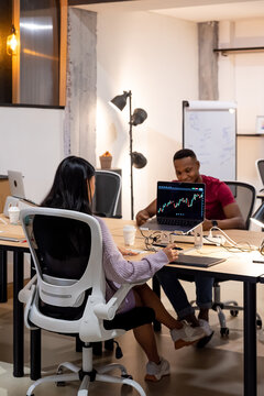 Female worker analyzing chart on monitor in office
