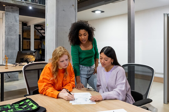 Diverse colleagues analyzing papers in office