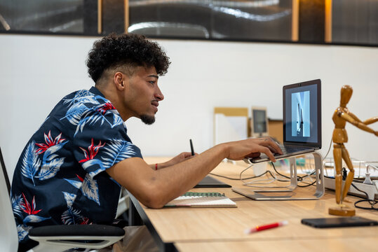 Serious black man working on computer in office