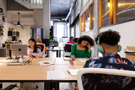 Multiracial colleagues working at desk in modern office