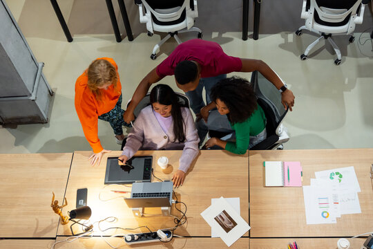 Diverse colleagues working with graphic designer in modern office