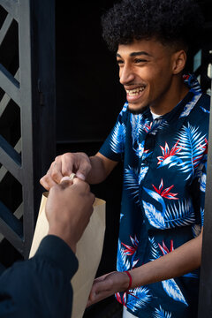 Happy black guy smiling while receiving parcel