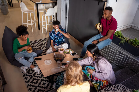 Hungry diverse friends having lunch together at coworking space