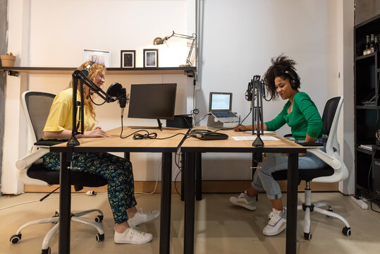Happy diverse radio hosts recording podcast in studio
