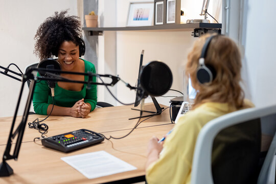 Happy diverse radio hosts recording podcast in studio