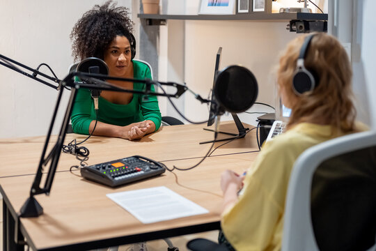 Happy diverse radio hosts recording podcast in studio